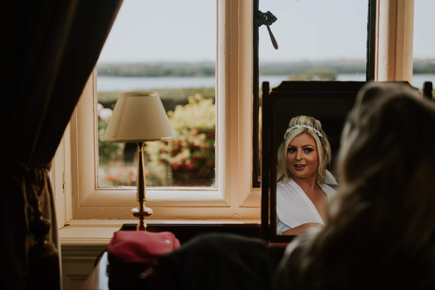 bride during bridal prep looking out of a barnsdale hall window