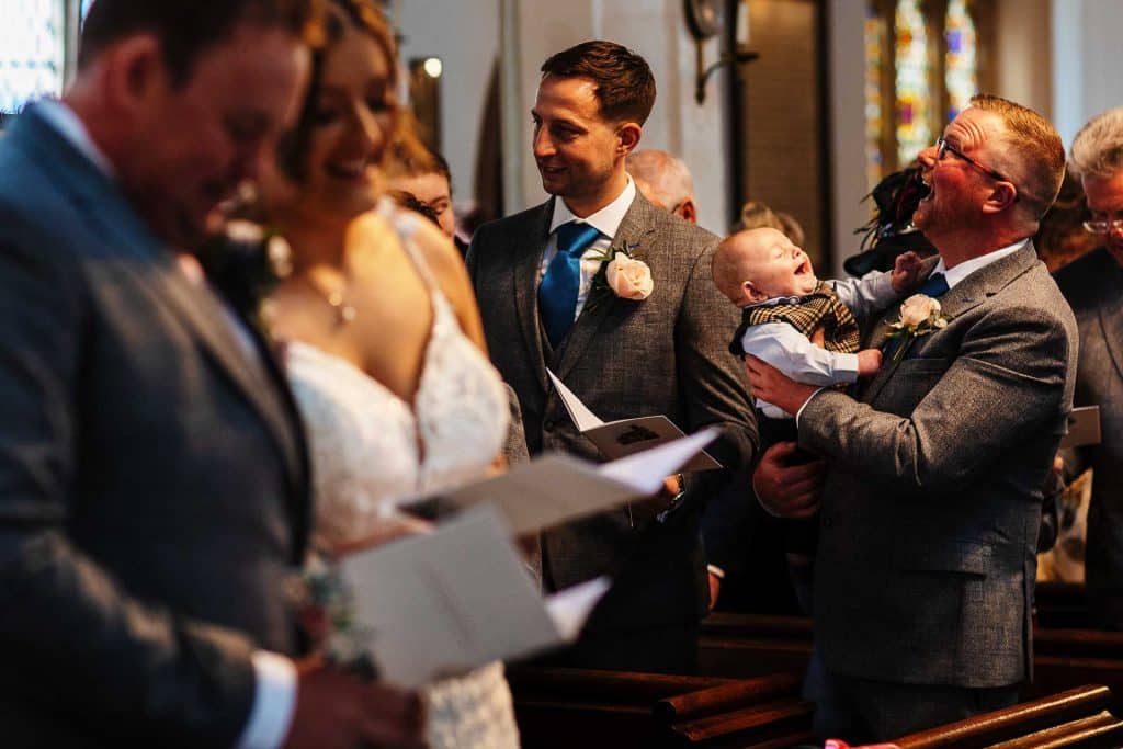 Joyful wedding ceremony with family and friends in a church, capturing heartfelt moments and celebration at BGS Weddings.