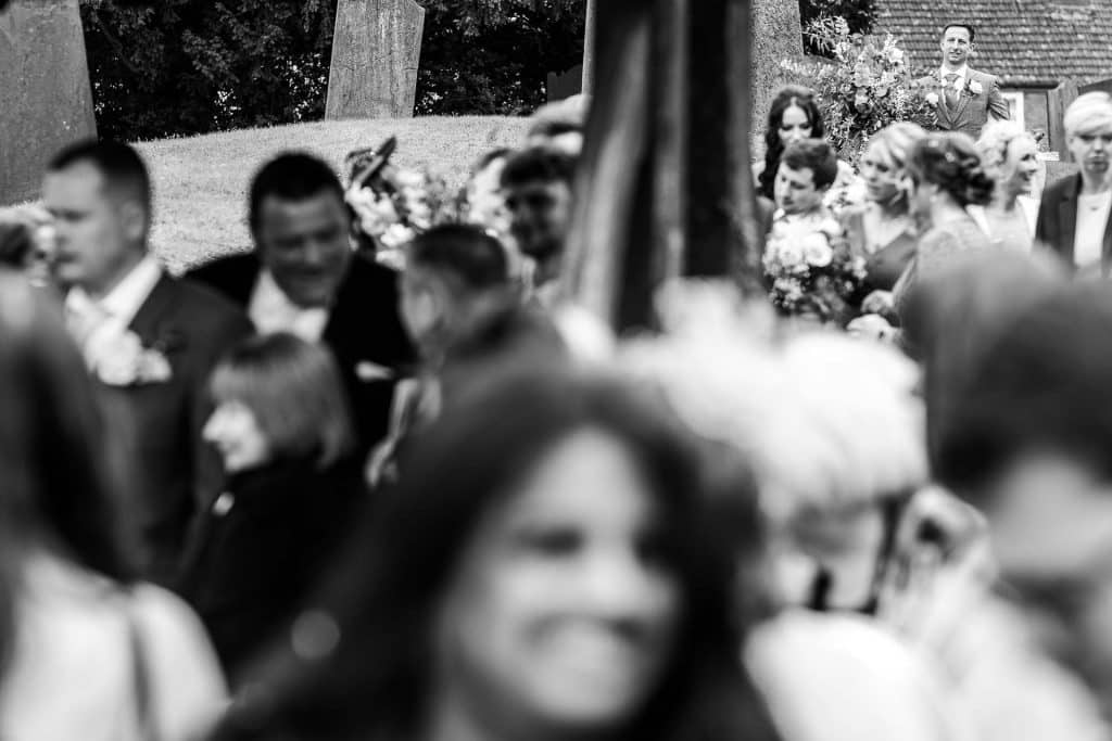 Elegant outdoor wedding guests gathered, celebrating amidst natural scenery with sophisticated attire, flowers, and joyful moments, captured beautifully by BGS Weddings.