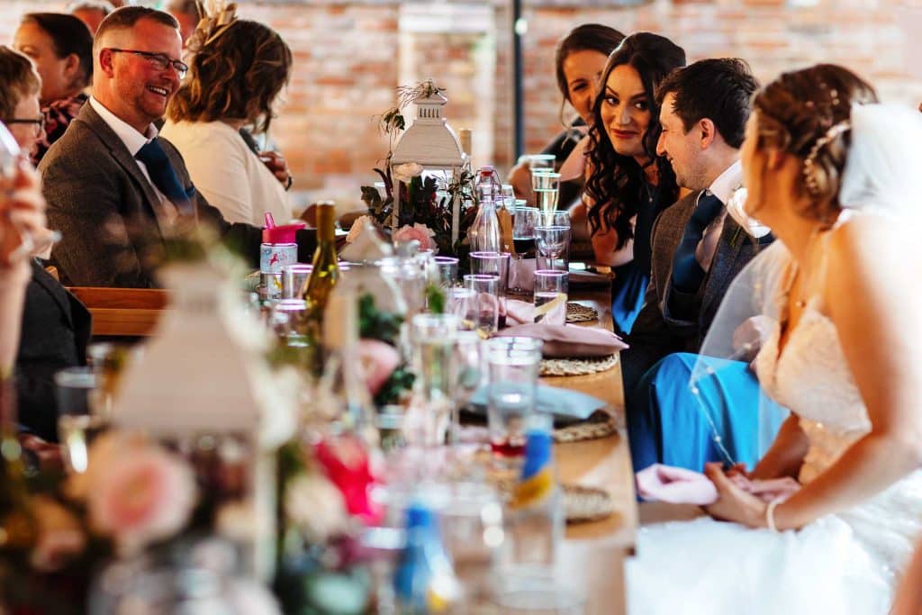 Elegant wedding reception at BGS Weddings, with guests enjoying a celebration dinner, floral arrangements, and rustic decor in a stylish venue setting.