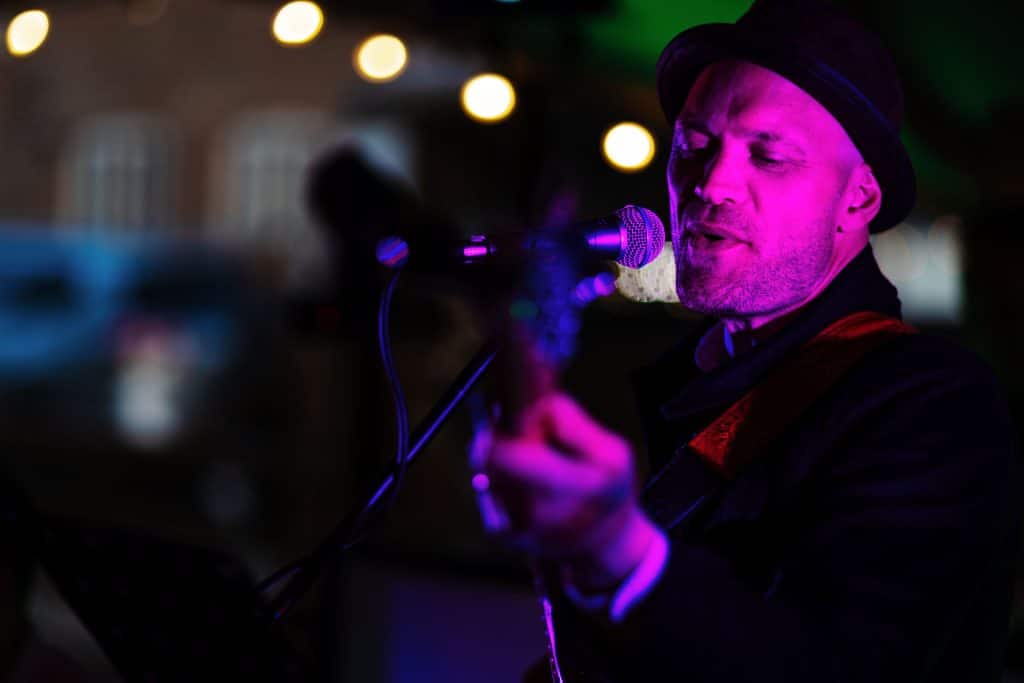 Live wedding singer performing with guitar at BGS Weddings, creating a romantic atmosphere for your special day in the UK. Book expert entertainment for memorable weddings.