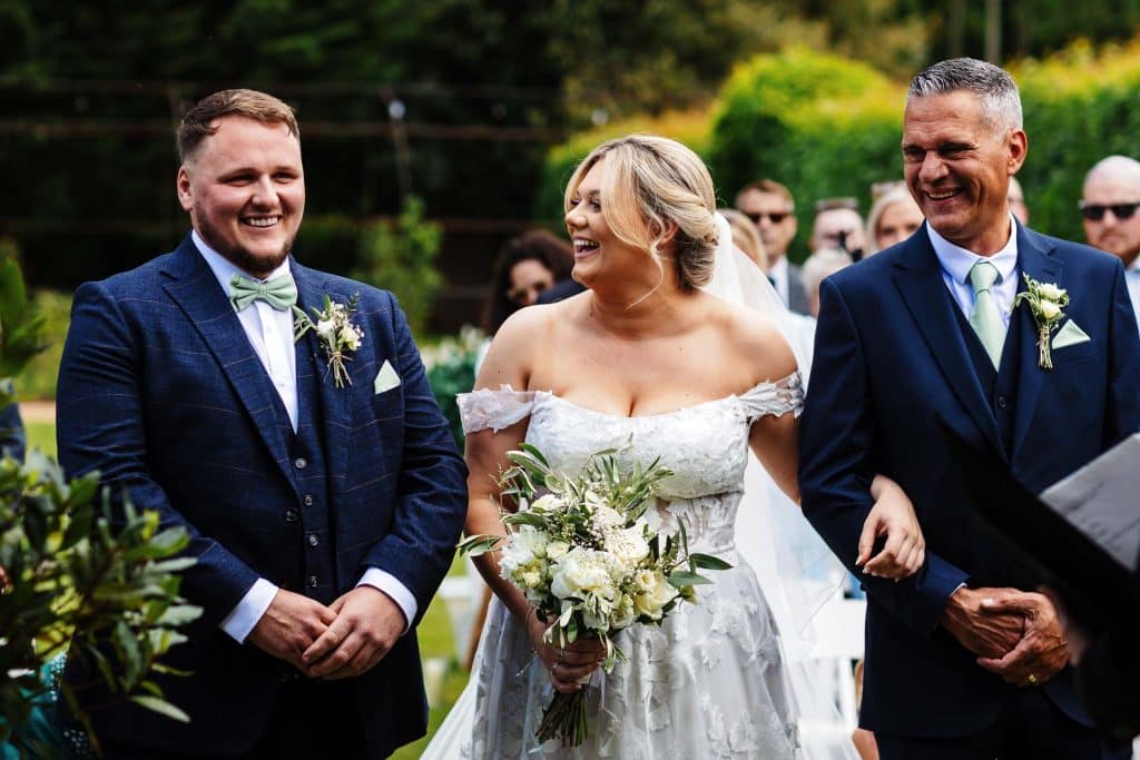 Beautiful outdoor wedding ceremony with bride and groom exchanging vows surrounded by family and friends at BGS Weddings. Elegant wedding attire and joyful moments captured.
