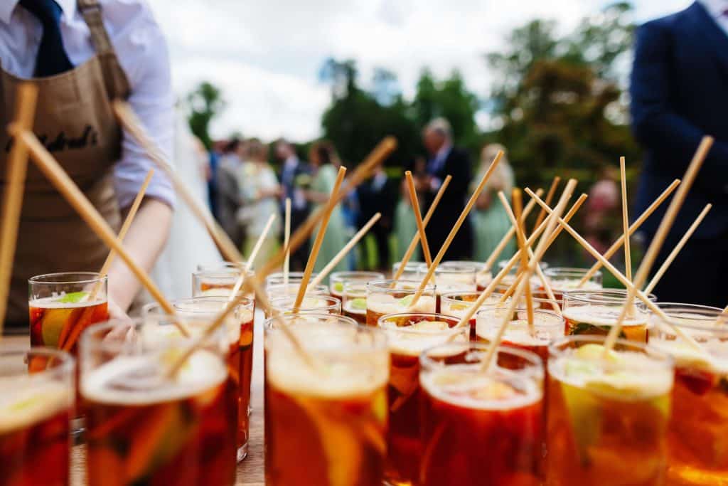 Refreshing summer cocktails served at an outdoor wedding reception, with guests enjoying drinks on a beautiful day, perfect for celebrating love and marriage.