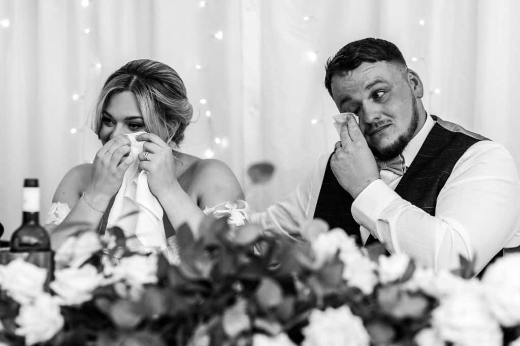 Tears of joy during a wedding reception, emotional couple sharing a heartfelt moment at their wedding celebration.