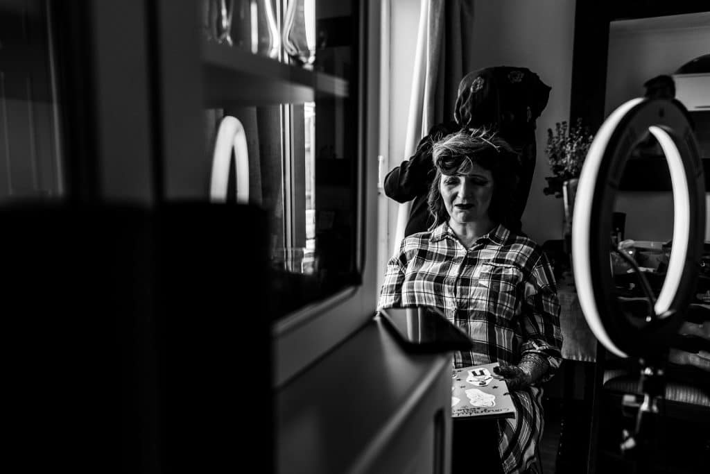 Elegant bride getting ready for wedding at BGS Weddings, professional makeup and hair styling, black and white photo capturing special moments.
