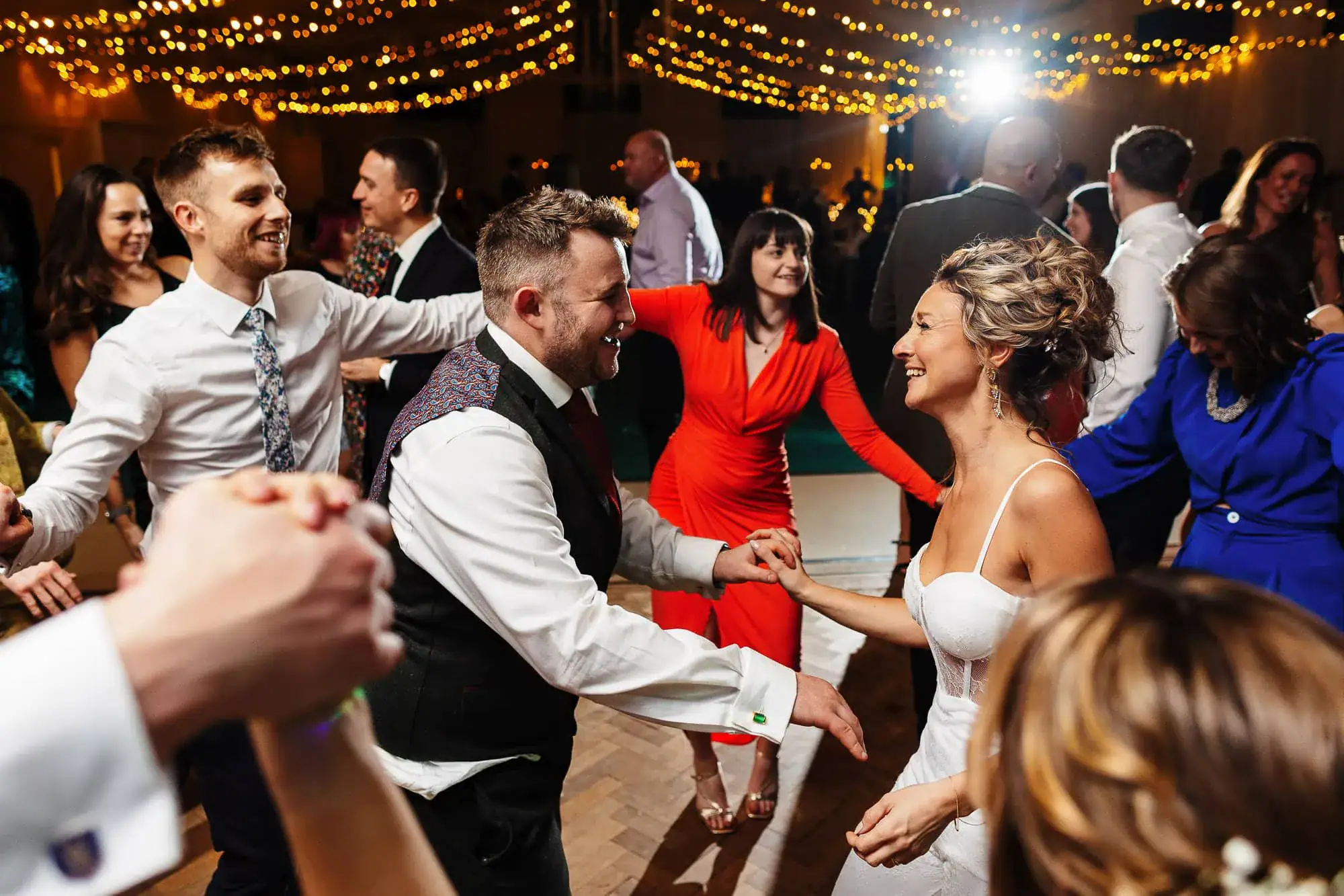 Elegant wedding dance scene at BGS Weddings venue with joyful guests, romantic lighting, and celebratory atmosphere. Perfect for wedding photography and event coverage.