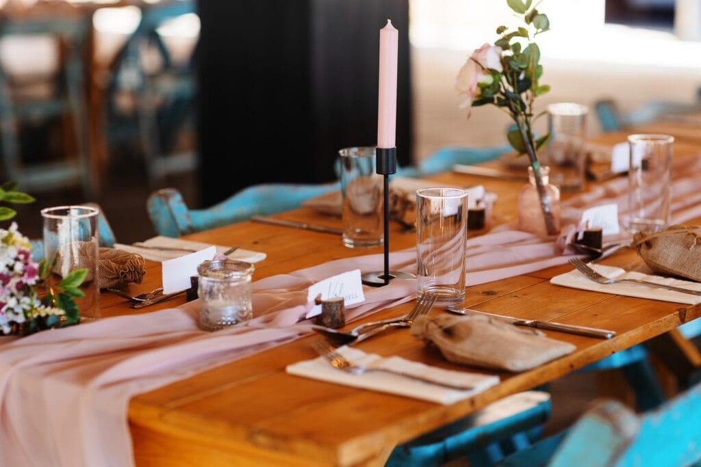 Elegant rustic wedding table setup with floral accents, candles, and inviting table settings, perfect for a memorable wedding reception organised by BGS Weddings.