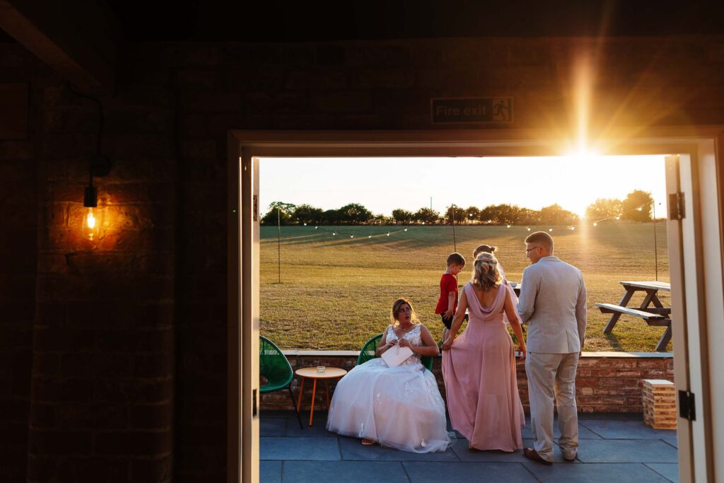 Vibrant wedding photo captured during sunset at BGS Weddings venue, featuring a bride, groom, and guests enjoying the outdoor celebration with beautiful natural lighting.