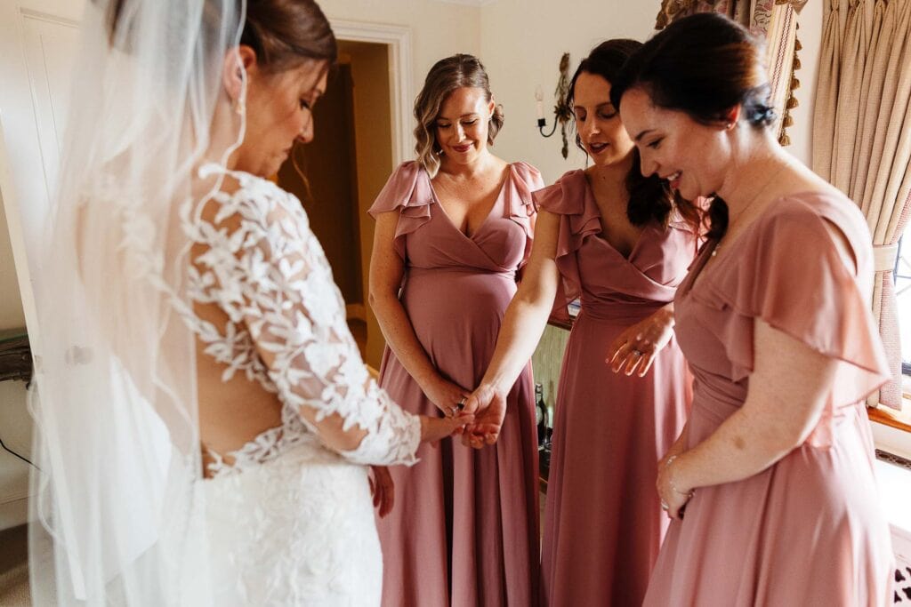 Elegant bridal moments with bridesmaids in blush pink dresses preparing for the wedding at BGS Weddings, capturing joyful wedding preparations and bridal photography.