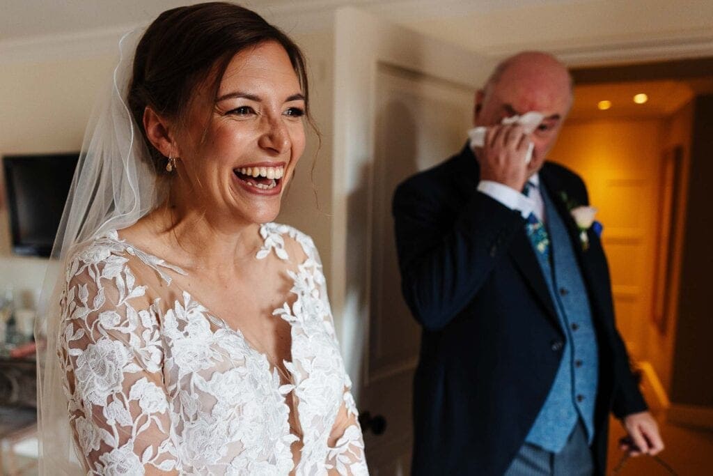Wedding bride smiling with her father in a heartfelt moment at BGS Weddings for an emotional wedding celebration in the UK.