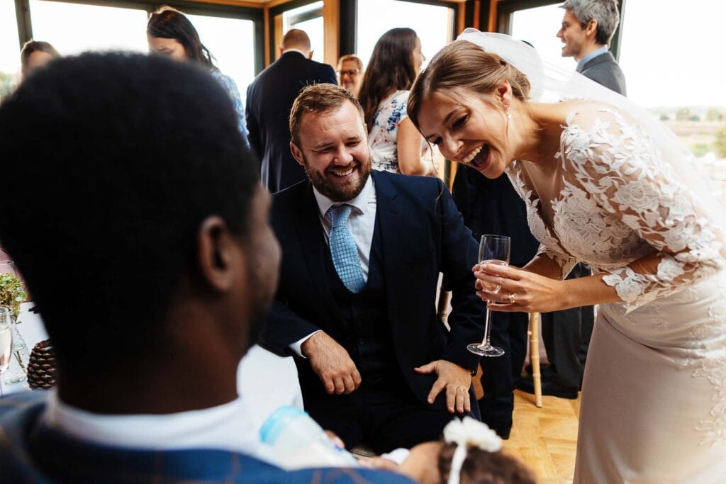 Elegant bride laughing with friends during wedding reception at BGS Weddings, celebrating love and joy with guests in a stylish, intimate venue.