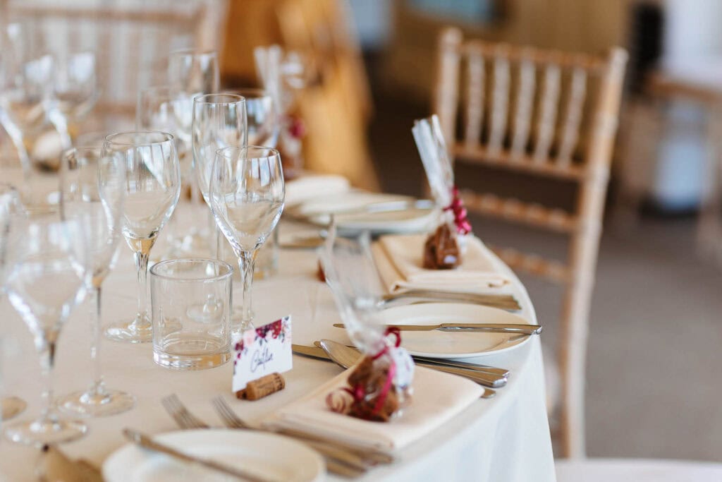 Elegant wedding reception table setup with glassware, cutlery, and decorated napkins for a stylish event at BGS Weddings.