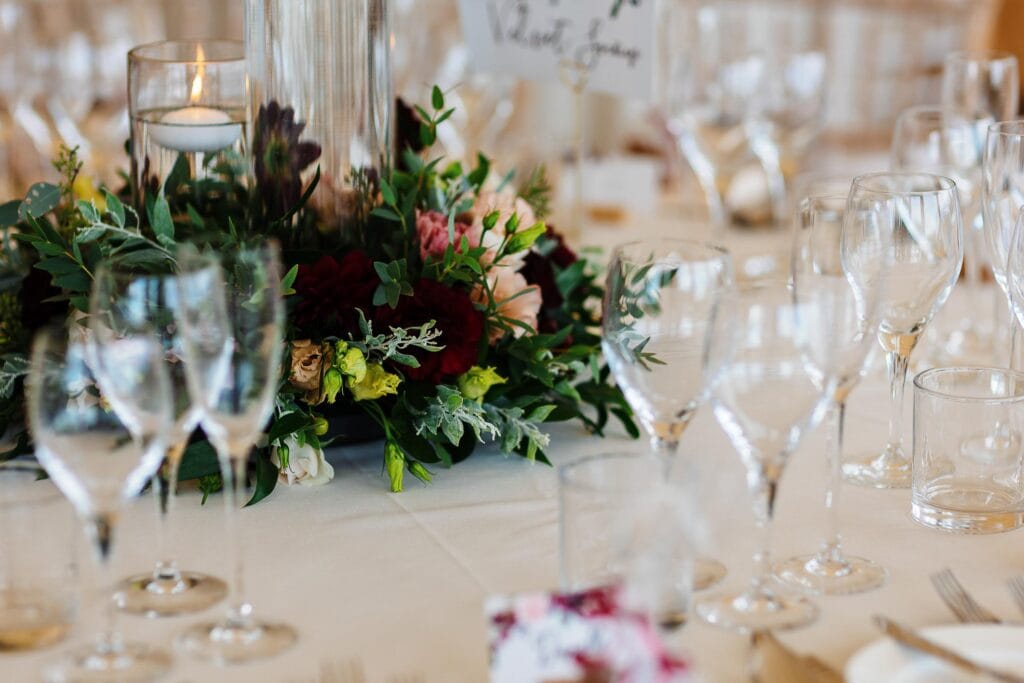 Elegant wedding table with floral centrepiece and glassware at BGS Weddings.