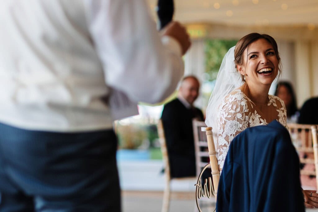 Elegant bride in lace wedding dress enjoying her special day at a wedding reception, captured by BGS Weddings.