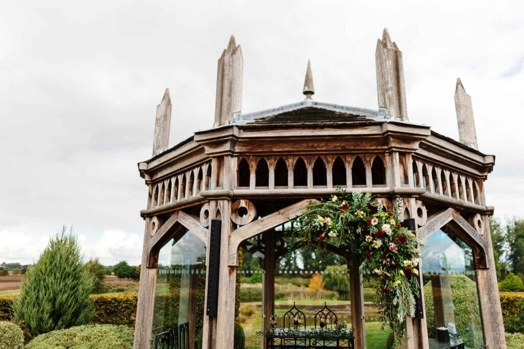 Elegant outdoor wedding gazebo with floral decorations, perfect for rustic and vintage wedding ceremonies at BGS Weddings venue, set in scenic countryside surroundings in the UK.