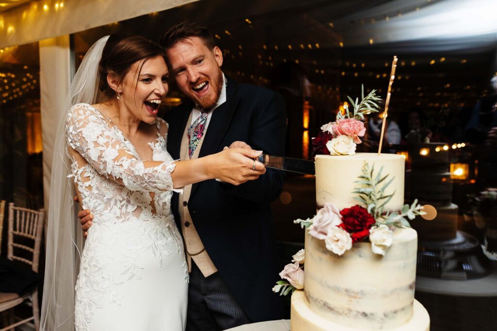 Elegant bride and groom cutting wedding cake at BGS Weddings, showcasing wedding celebration and cake decoration service in a romantic ceremony.