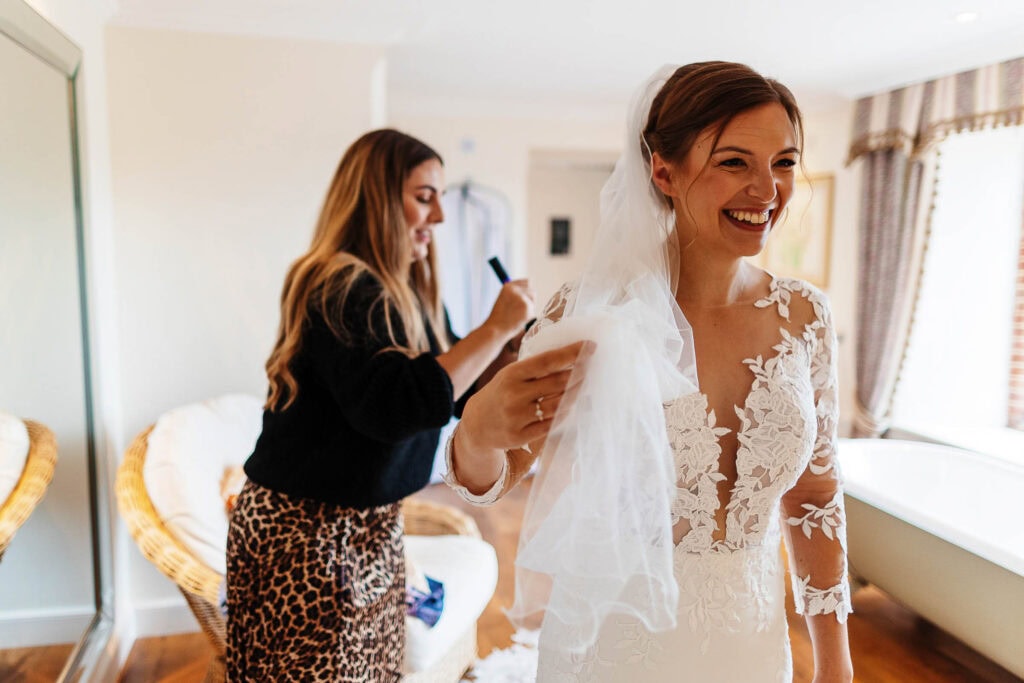 Elegant bride getting ready on her wedding day, guided by a stylist, showcasing bridal beauty and wedding preparations.