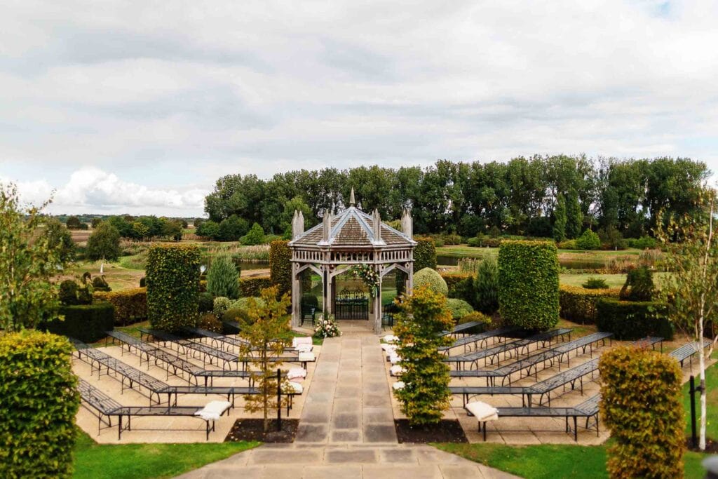 Beautiful outdoor wedding gazebo surrounded by well-manicured gardens and seating area, perfect for outdoor wedding ceremonies at BGS Weddings in the UK.
