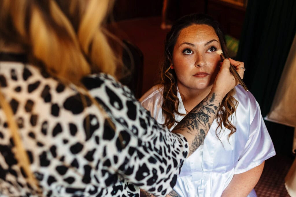 Natural makeup application on bride at wedding preparation, professional makeup artist applying makeup for a wedding, bridal beauty, getting ready for the wedding day, BGS Weddings.