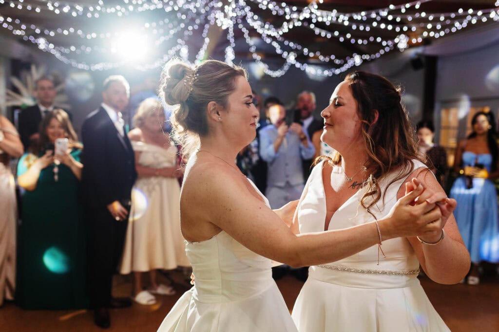 Beautiful same-sex wedding dance at BGS Weddings, featuring joyful brides sharing a special moment on the dance floor with wedding guests in a beautifully decorated venue.