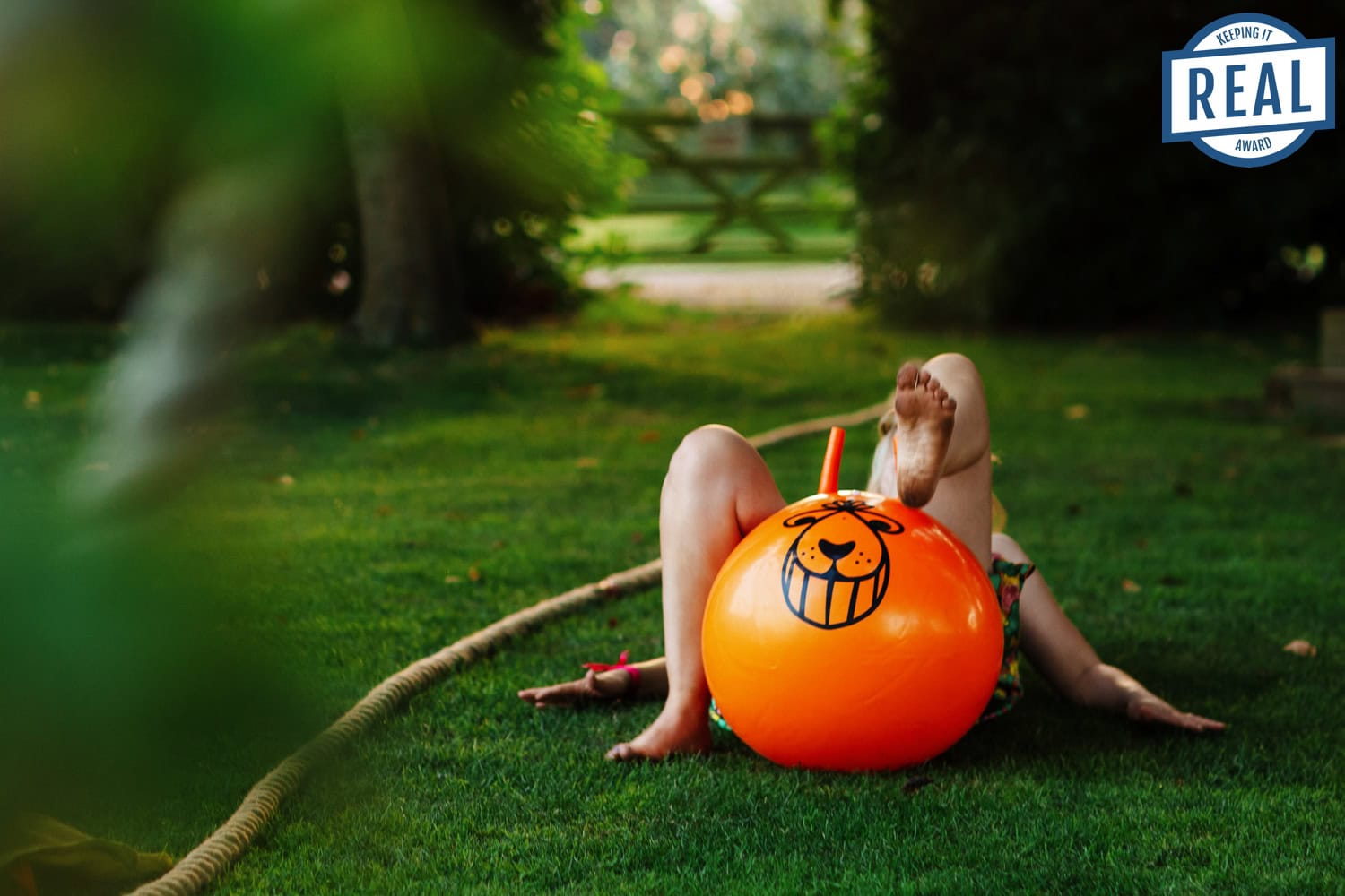 Bounce house fun at outdoor wedding celebration on lush green lawn with children playing, colourful decorations, and natural garden setting, perfect for family-friendly wedding events, BGS Weddings.