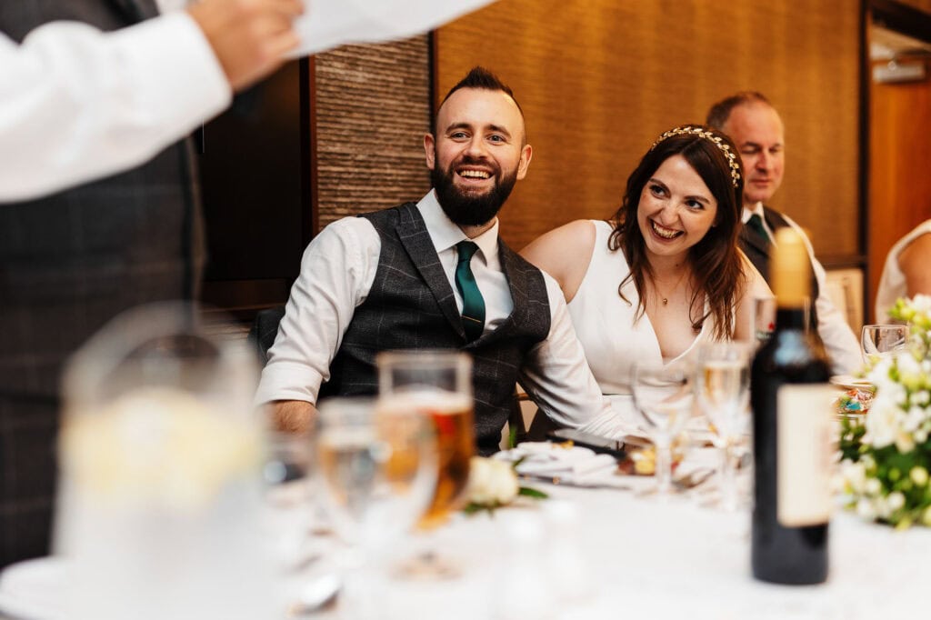 Elegant wedding reception with smiling bride and groom, celebrating their special day at BGS Weddings venue, featuring sophisticated decor and joyful atmosphere.