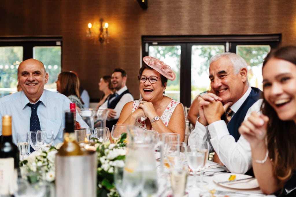 Joyful wedding guests laughing and enjoying a celebration at BGS Weddings, showcasing elegant event planning and catering services in the UK.