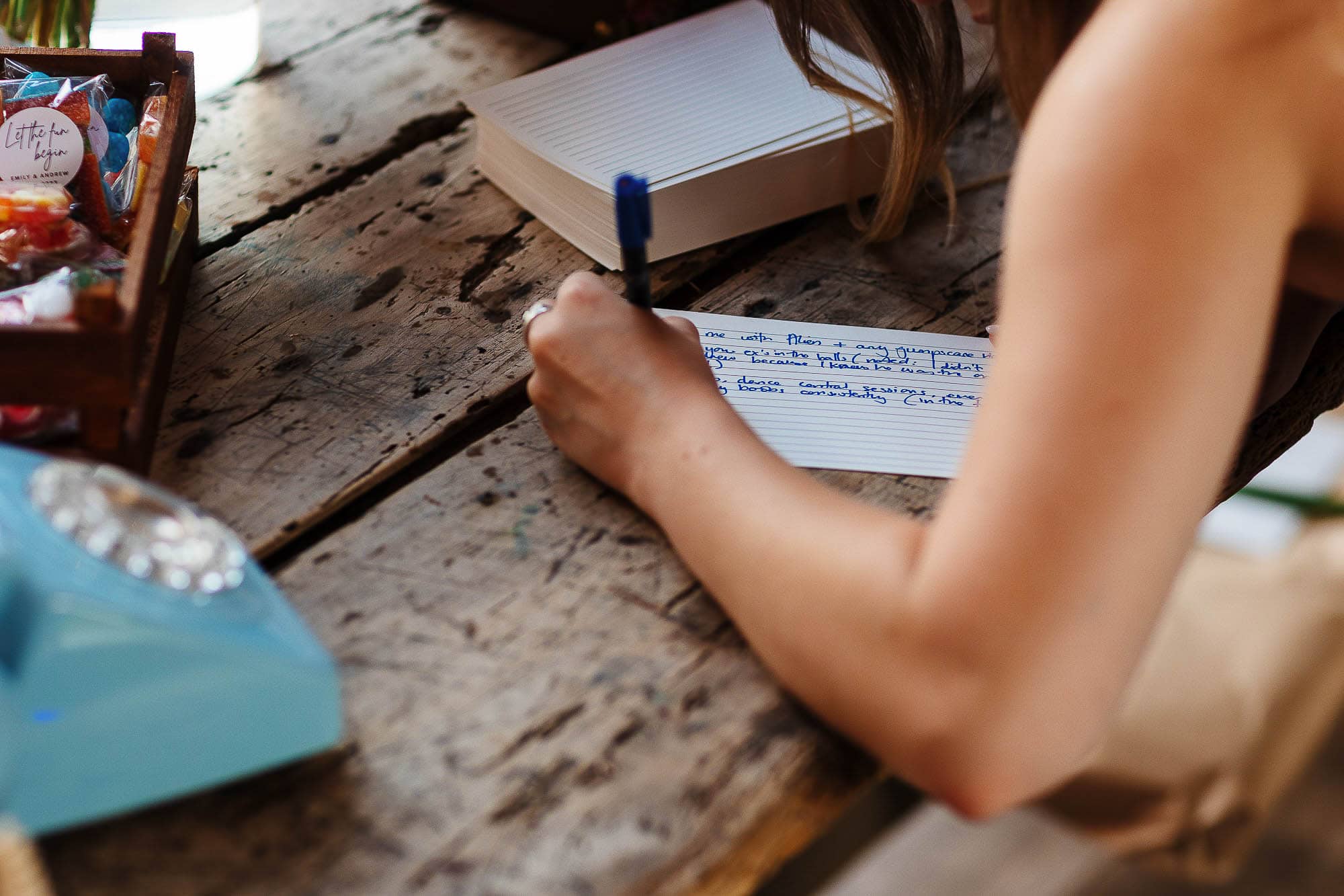 Handwritten wedding guest book entry on rustic wooden table at BGS Weddings.
