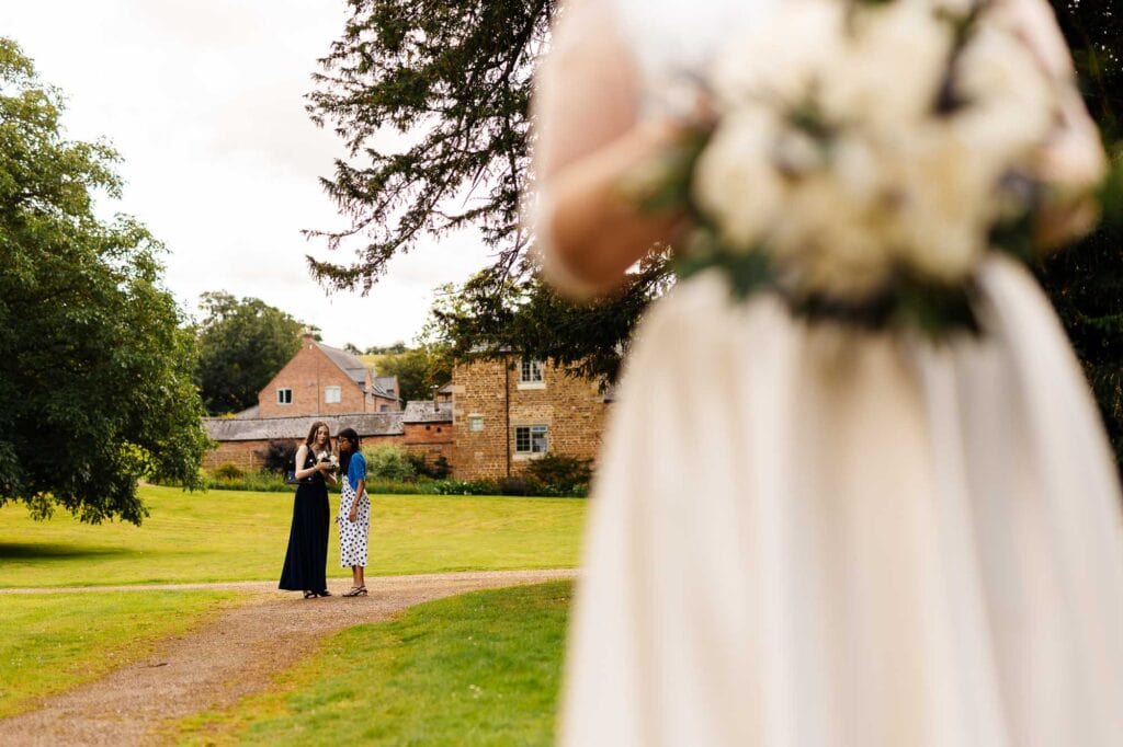 Elegant wedding scene at BGS Weddings with bridesmaids and a wedding dress in a picturesque outdoor setting, highlighting wedding photography and venue in the UK.