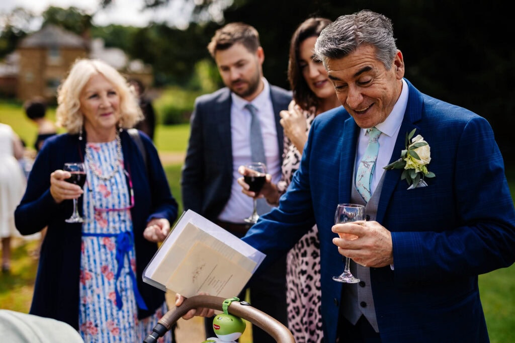 Elegant outdoor wedding celebration with guests raising glasses, joyful conversations, and the bride and groom enjoying a memorable moment in a lush garden setting.