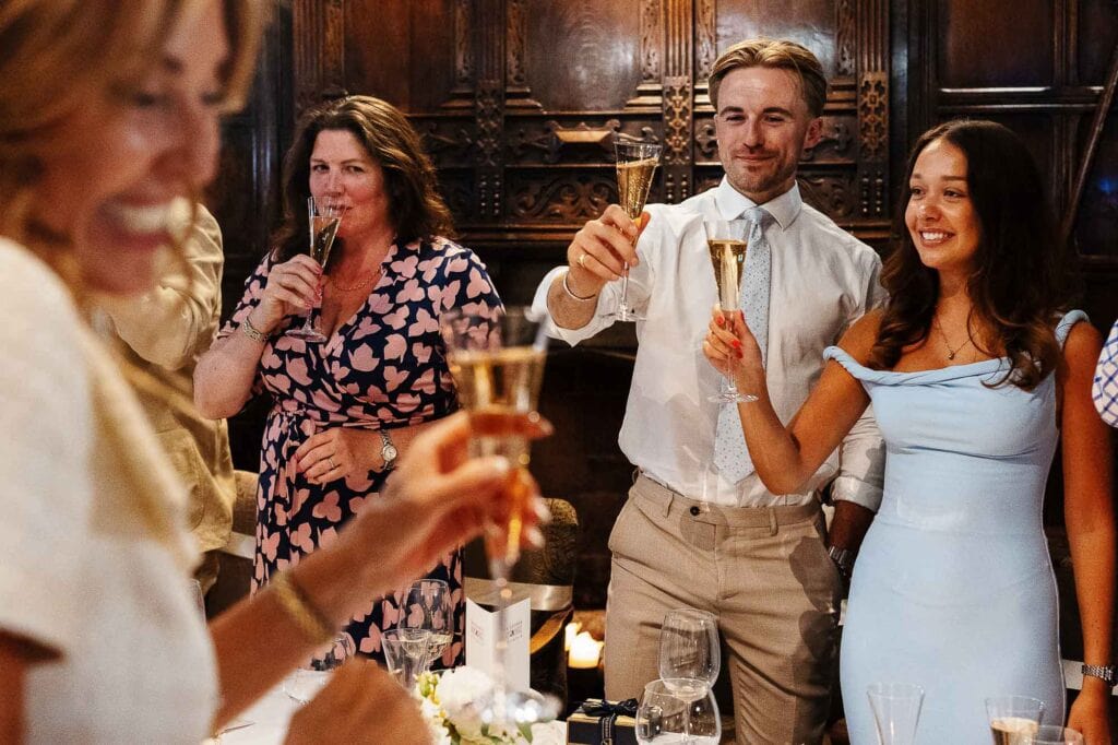 Elegant wedding celebration with guests raising champagne flutes, showcasing joyful moments during a wedding reception at BGS Weddings.
