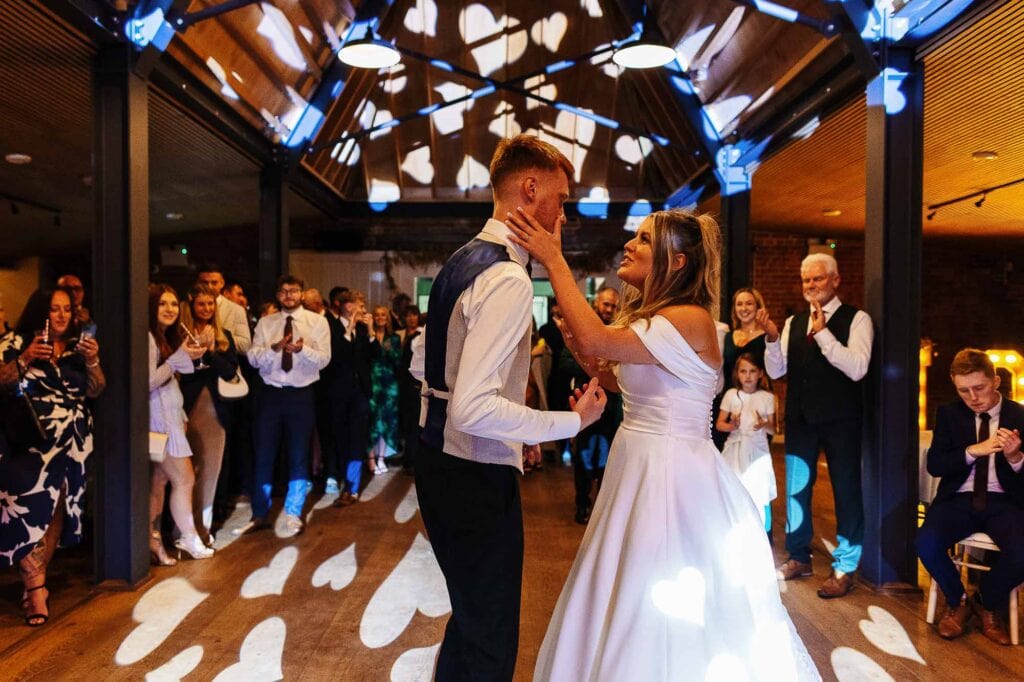 Wedding photography at pheasantry brewery Elegant bride and groom dancing at wedding reception, surrounded by joyful guests at BGS Weddings, a popular venue for romantic wedding celebrations and receptions in the UK.