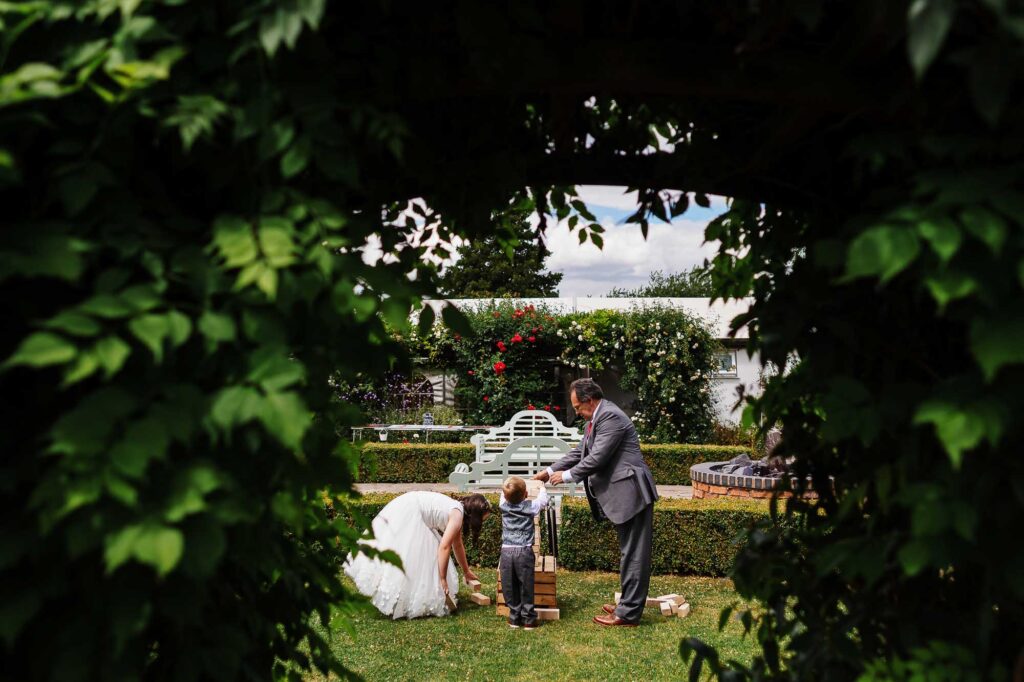 Kids playing outdoor giant Jenga game during wedding reception at BGS Weddings, a beautiful venue in the UK with lush garden settings and romantic outdoor decor.
