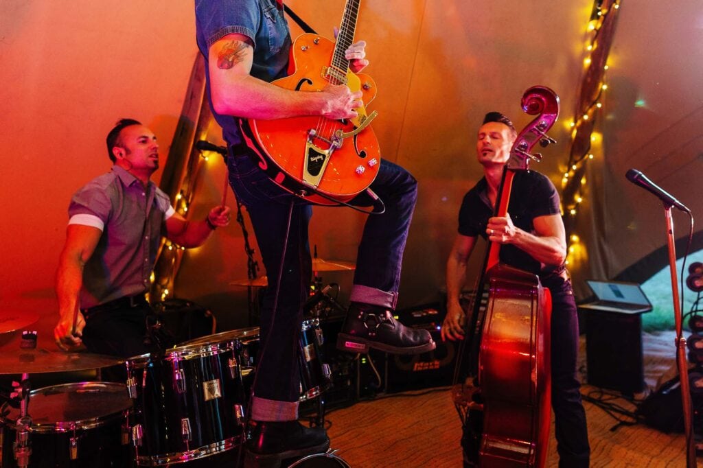 Energetic live band performing at a wedding reception with vibrant lighting and musical instruments, creating a lively and memorable celebration atmosphere.