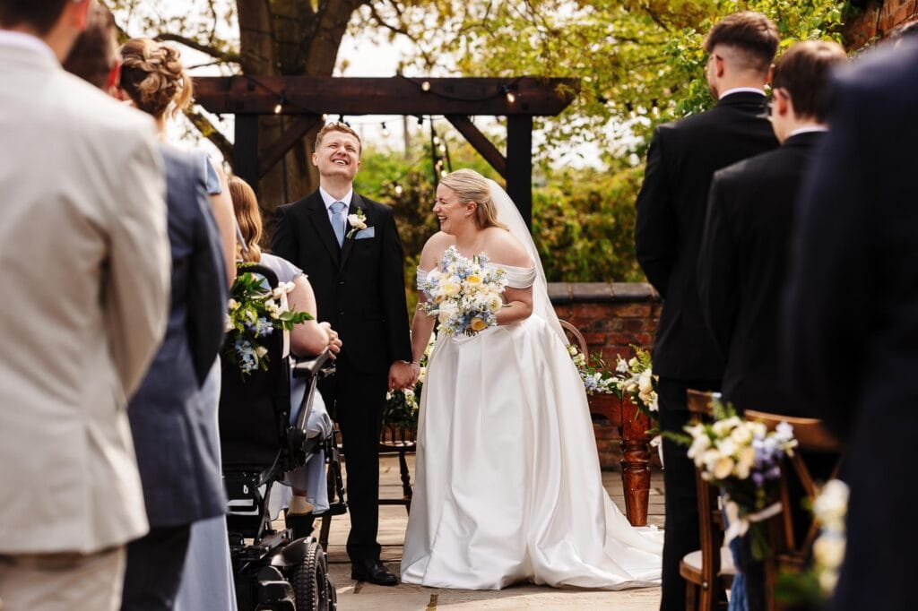 Beautiful outdoor wedding ceremony with bride and groom exchanging vows, surrounded by friends and family in a charming garden setting.