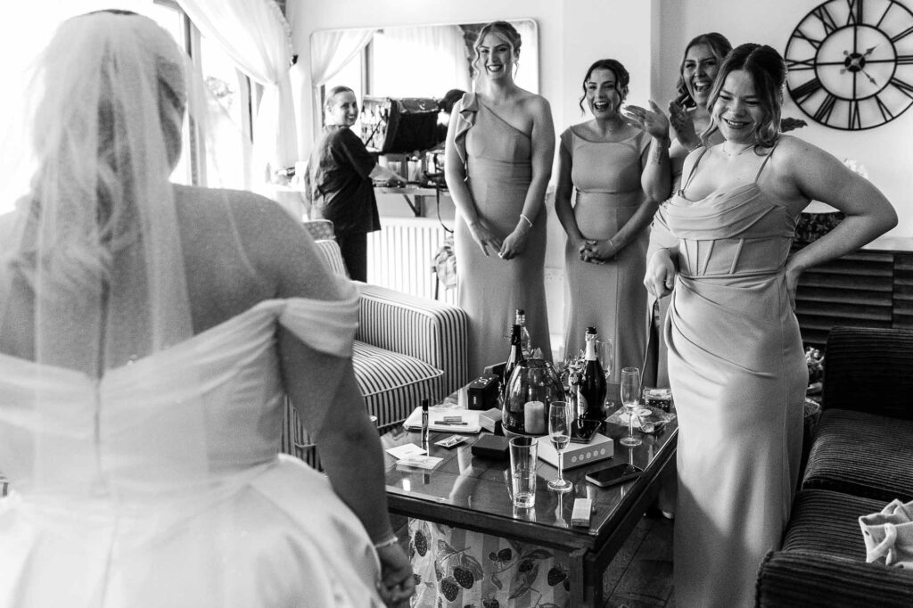 Elegant bride preparing with her bridesmaids in a cosy, stylish room before the wedding ceremony, capturing joyful moments and friendship.