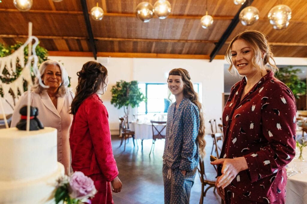 Celebrating a wedding with joyful women in a beautifully decorated venue, featuring warm lighting, wooden ceiling, and elegant floral arrangements, creating a festive and welcoming atmosphere.