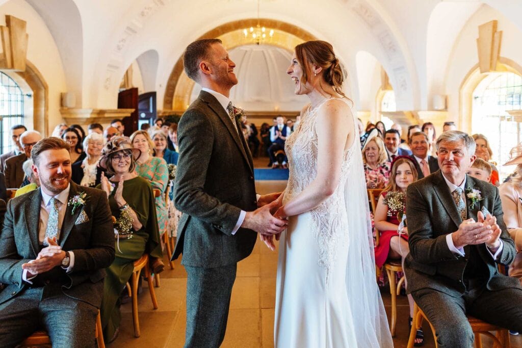 Beautiful couple exchanging vows during a wedding ceremony at BGS Weddings, with guests witnessing in a stunning, elegant setting.