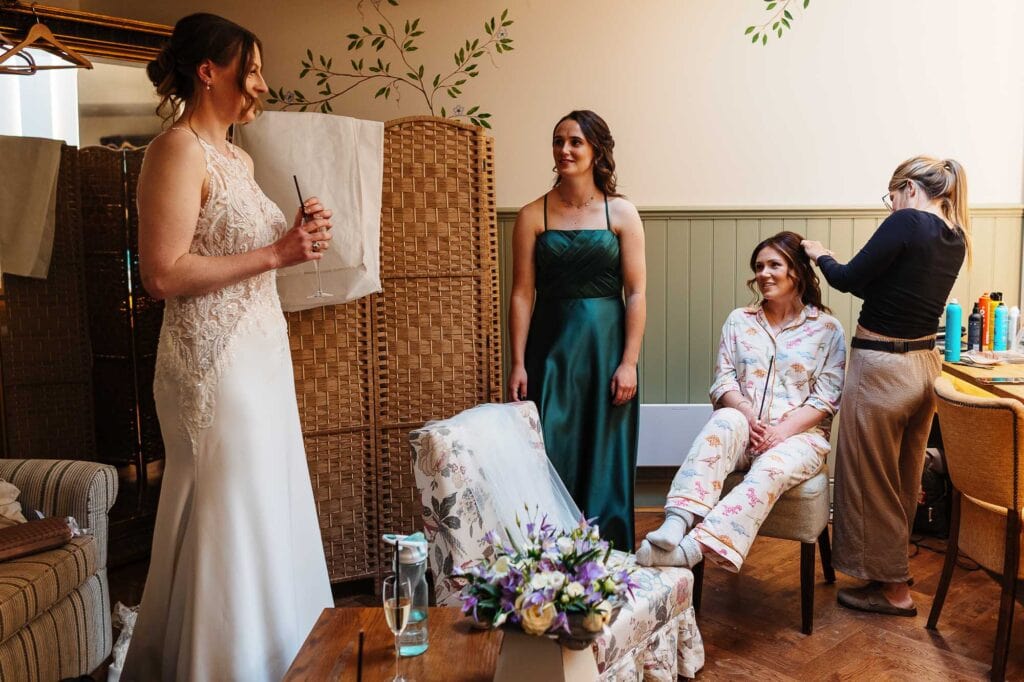Bride and bridesmaids getting ready for the wedding, with the bride holding a notepad and the bridesmaids in elegant dresses.