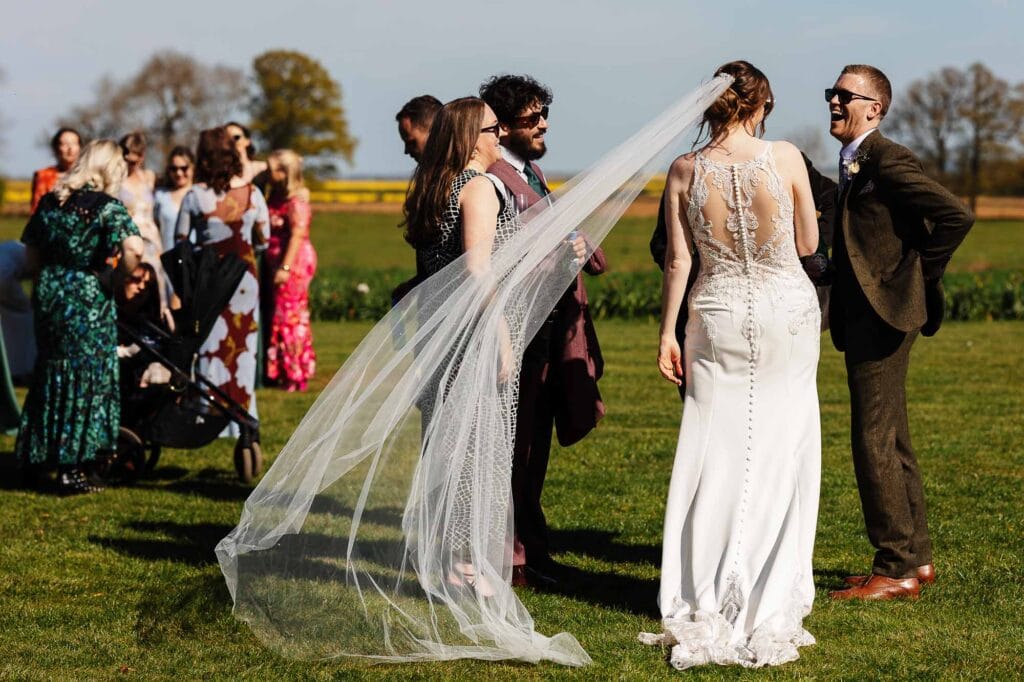 Bride and groom sharing a moment during their wedding ceremony outdoors on a sunny day.
