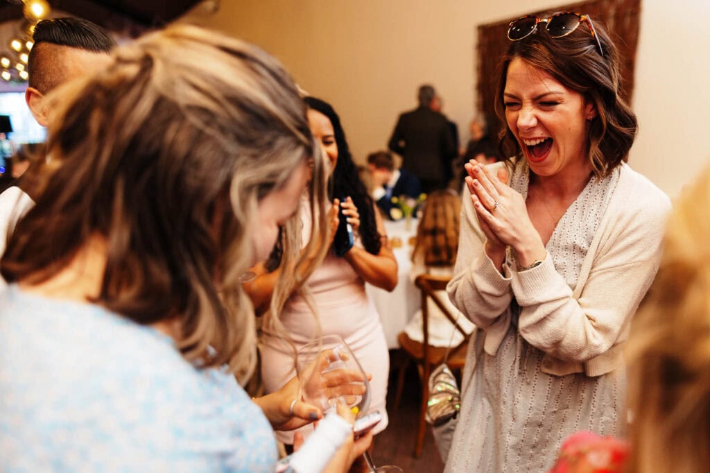 A joyful woman celebrating with friends at a wedding reception, capturing the happiness and excitement of the special day.