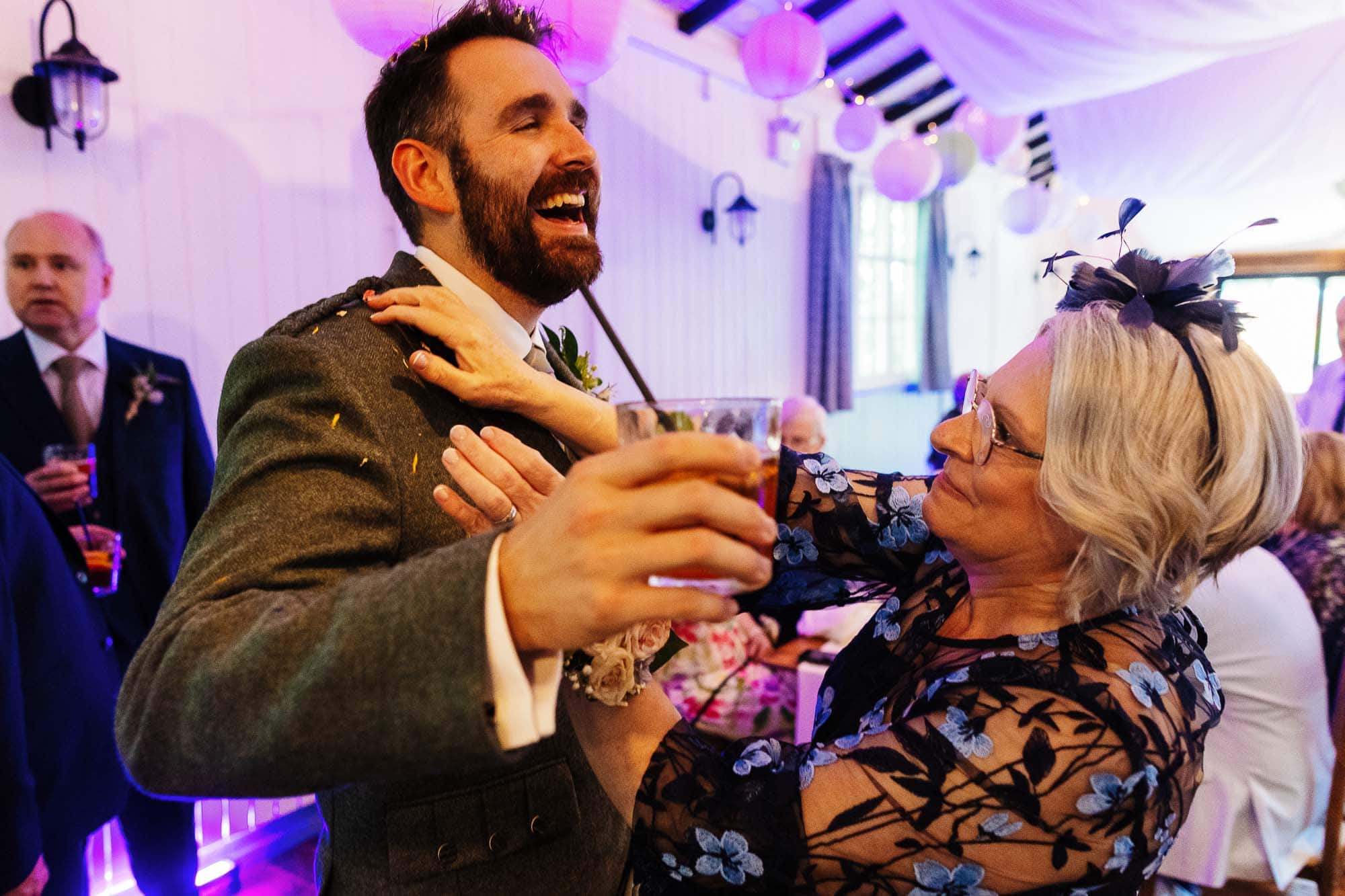 Happy bride and groom dancing with family and friends during a wedding reception.