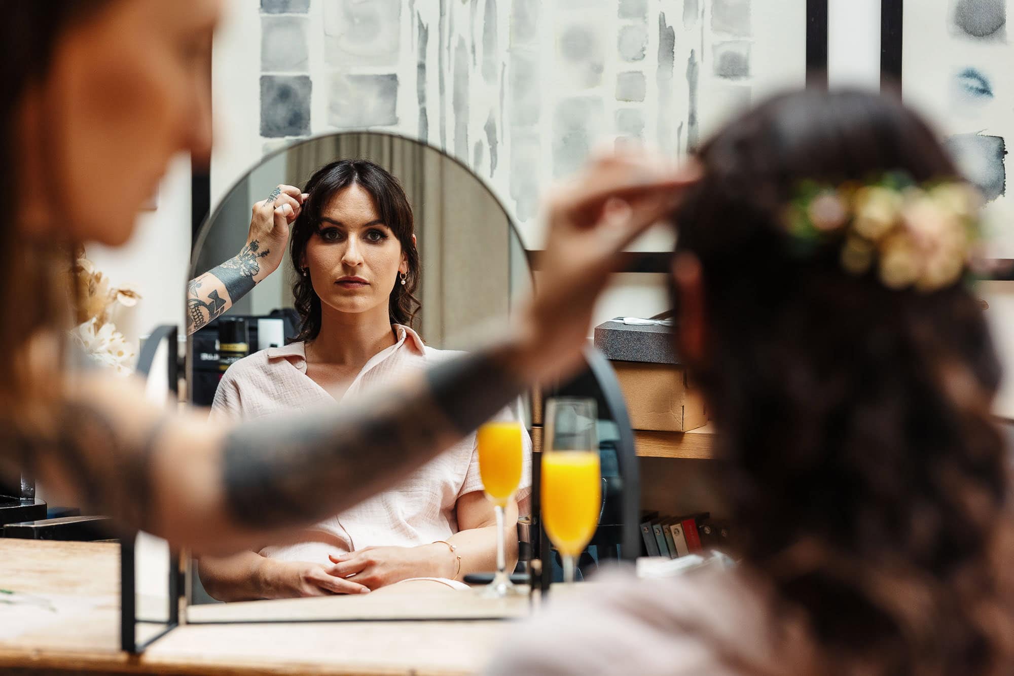 Bride preparing for her wedding with professional makeup artist in a modern salon setting.