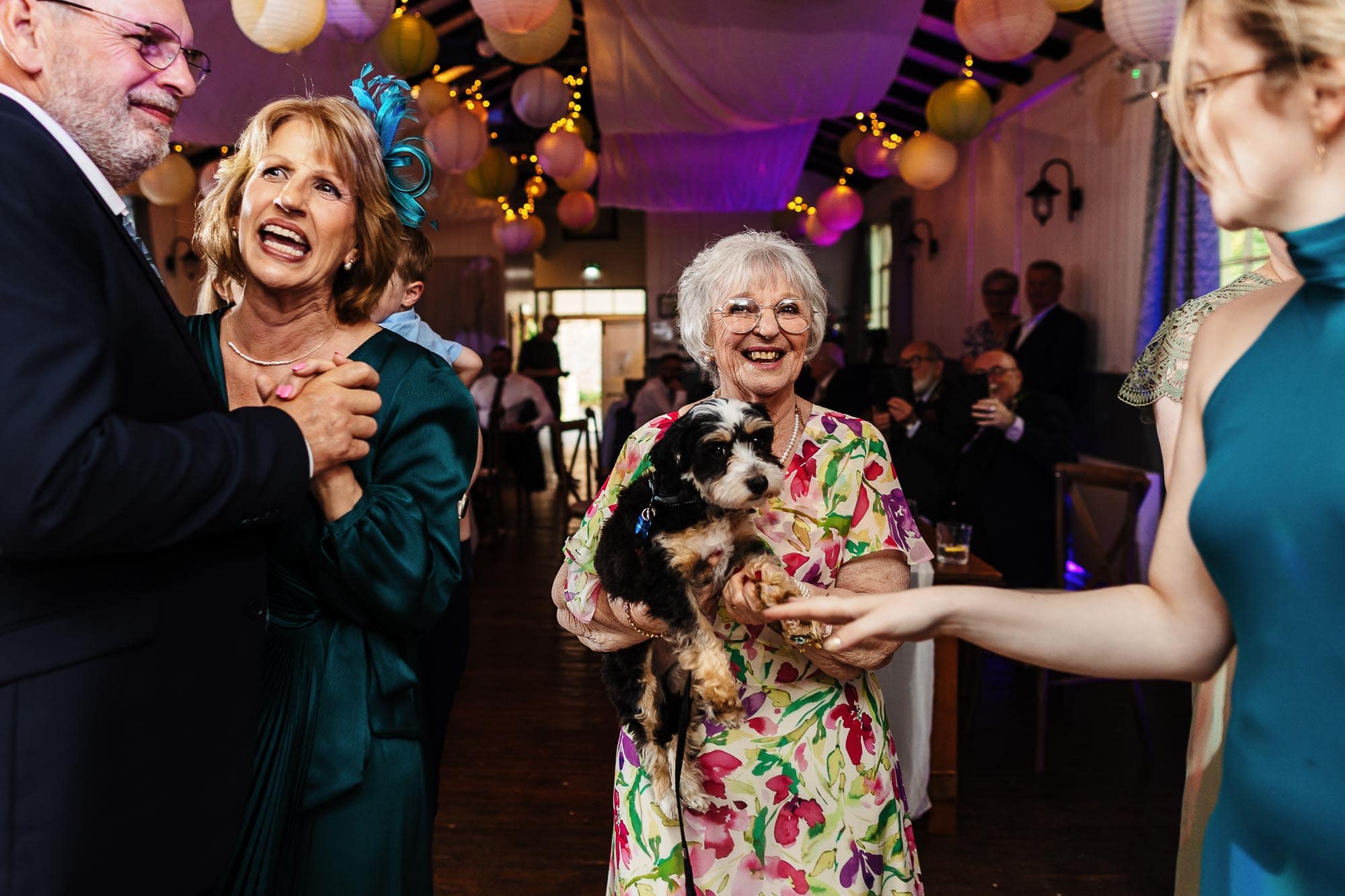 Joyful wedding reception with guests dancing and celebrating, colourful decorations, and a happy atmosphere at BGS Weddings.