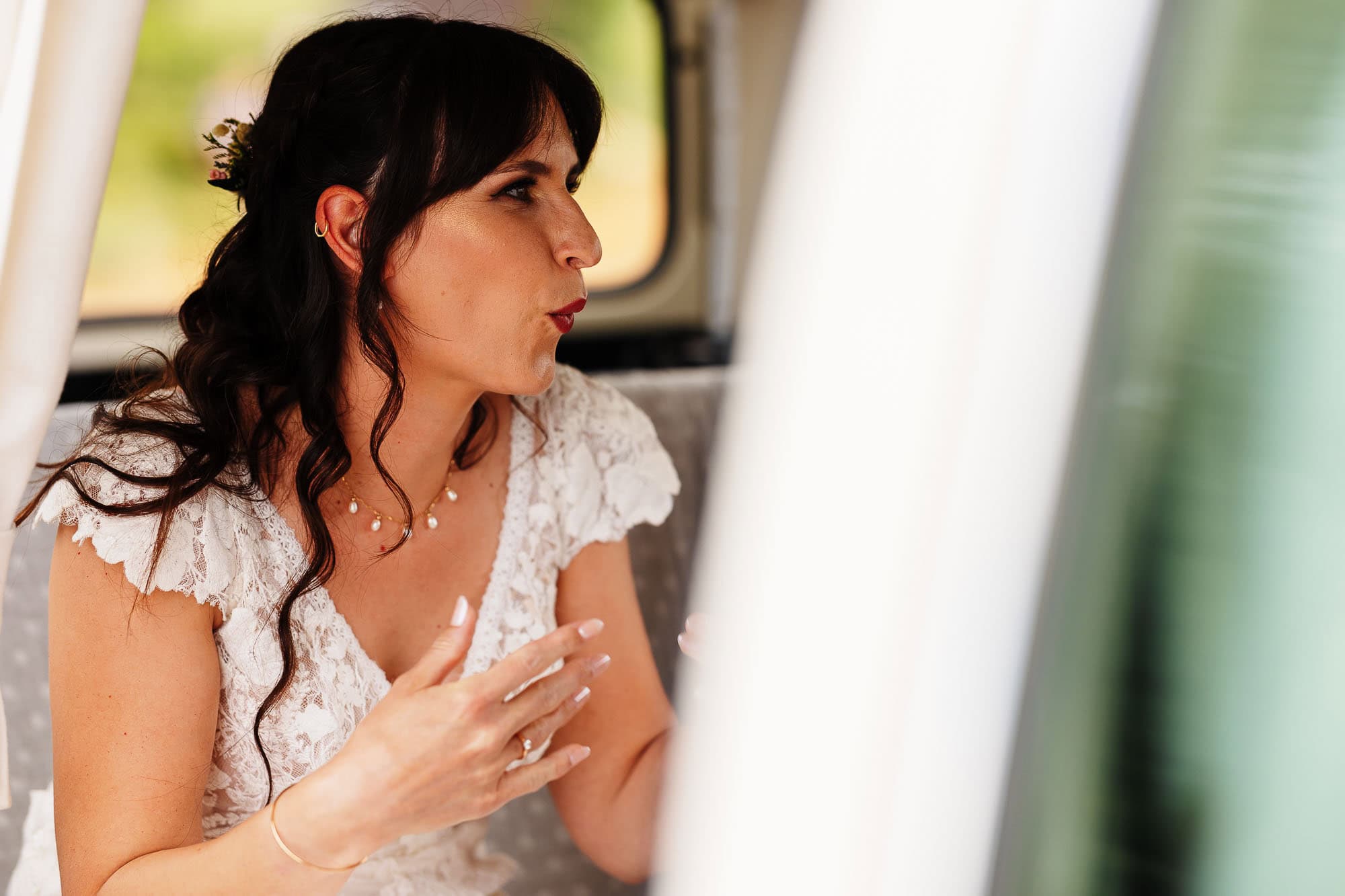 Bride getting her makeup done in a vehicle before her wedding ceremony, showcasing professional bridal makeup services.