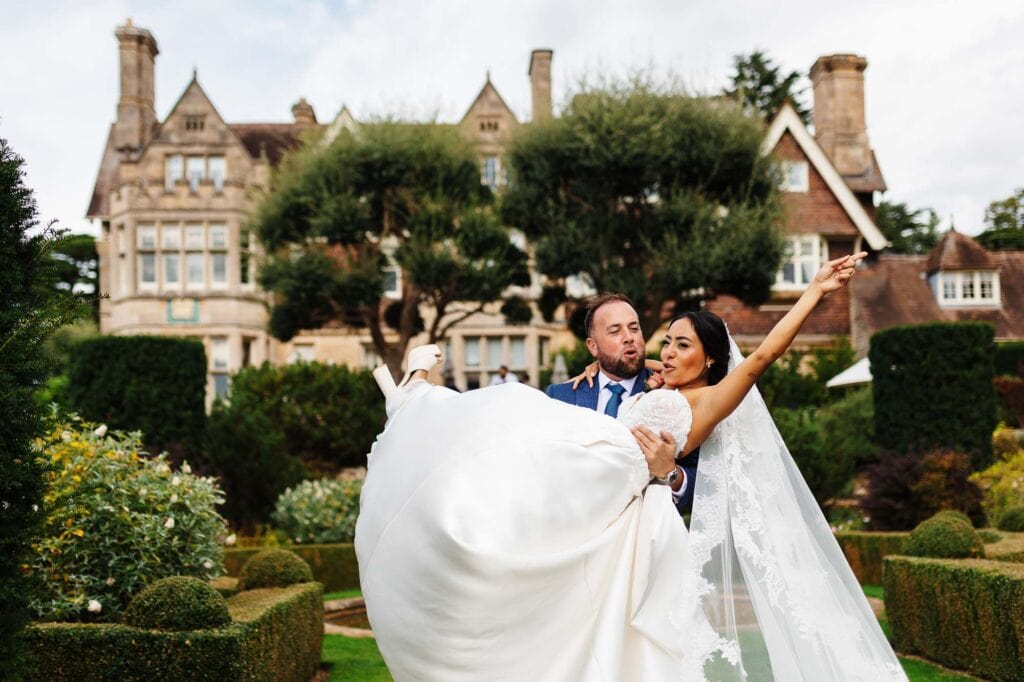 Bride and groom dancing outdoors at BGS Weddings, with a historic mansion in the background, showcasing a romantic wedding scene.